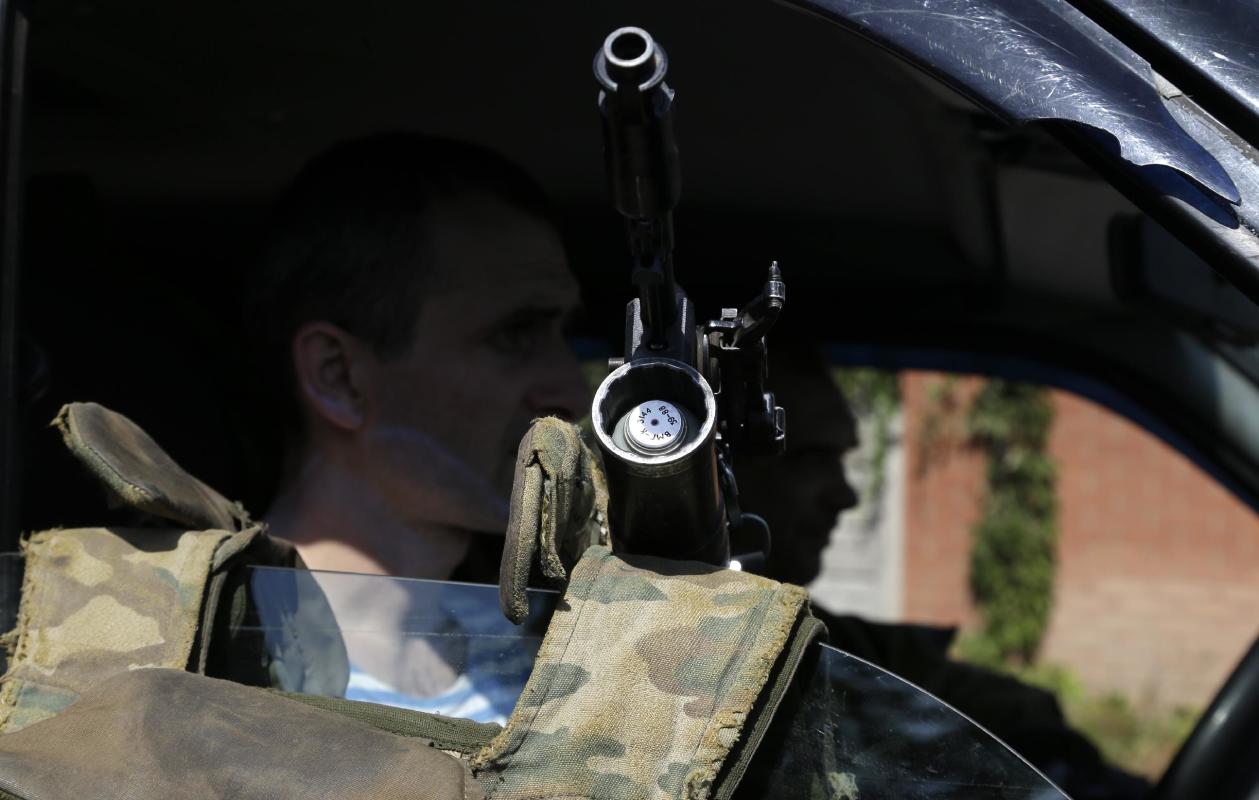 Pro-Russian rebels sit in their car in Donetsk, eastern Ukraine, Sunday, Sept. 7, 2014. Strong explosions were heard early Sunday on the outskirts of the main rebel-held city in eastern Ukraine near the airport, raising new fears that a cease-fire signed two days ago is on the verge of collapse. Blasts powerful enough to be heard in downtown Donetsk came from the area near the airport, which has been under the control of government troops since May and has come under unremitting attacks from pro-Russia separatist rebels since then. (AP Photo/Sergei Grits)