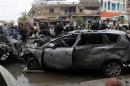 Residents gather at the site of a car bomb attack in Baghdad's