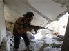 A Free Syrian Army fighter holds his rifle as he walks through an apartment destroyed by a tank shell during clashes with Syrian Army soldiers in the Salah al- Din neighbourhood in central Aleppo