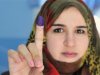 A woman shows her ink-stained finger after casting her vote in the National Congress election, in Benghazi