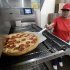 FILE - In this Thursday, May 24, 2012, file photo, employee Rosy Tirado pulls a pepperoni pizza from an oven at a Pizza Patron Dallas, Texas. While lower-wage American workers have accounted for the lion's share of the jobs created since the 2007-2009 Great Recession, a survey released March 2013 shows that they are also among the most pessimistic about their future career prospects, their job security and their finances. (AP Photo/Tony Gutierrez)