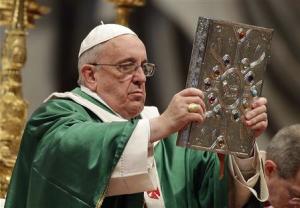 Pope Francis holds the Book of the Gospels as he celebrates a mass in Saint Peter's Basilica at the Vatican