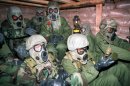 U.S. army soldiers wearing gas masks and chemical suits huddle in a bunker in Eastern Saudi Arabia after American planes began bombing Iraq in January 1991.