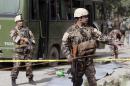 Afghanistan's security forces personnel stand guard at the site of a suicide attack in Kabul, Afghanistan, Wednesday, July 2, 2014. A suicide bomber attacked an air force bus in Kabul early Wednesday, killing at least four people, security officials said. (AP Photo/Rahmat Gul)