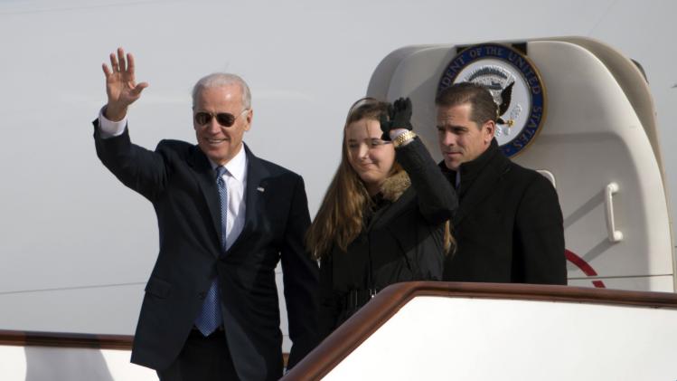 U.S. Vice President Biden waves as he walks out of Air Force Two with his granddaughter Biden and son Biden at the airport in Beijing