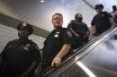 Policemen ride down an escalator as they can patrol the Times Square subway station in the Manhattan borough of New York