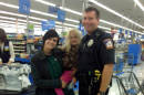 This photo provided by Walmart shows Emmett Township, Mich., Department of Public Safety Officer Ben Hall, right, with Alexis DeLorenzo, her daughter and the child's seat he purchased for them. Hall was on patrol Friday, Oct. 3, 2014, in the southern Michigan community when he pulled over DeLorenzo's vehicle after someone reported that it had an unsecured young child inside. DeLorenzo said she knew that they could have been ticketed, but instead, Hall told her to meet him at a Wal-Mart, where he bought her the seat. (AP Photo/Walmart)