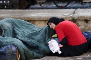 Migrants rest at the train station in Gevgelija