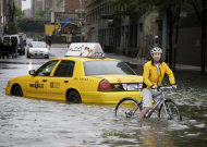 FILE - In this Aug. 28, 2011 file photo, a bicyclist makes his way past a stranded taxi on a flooded New York City street as Tropical Storm Irene passes through the city. From Cape Hatteras, N.C., to just north of Boston, sea levels are rising much faster than they are around the globe, putting one of the world's most costly coasts in danger of flooding, according to a new study published Sunday, June 24, 2012, in the journal Nature Climate Change. By the year 2100, scientists and computer models estimate that sea levels globally could rise as much as 3.3 feet. The accelerated rate along the East Coast could add about another 8 to 11 inches, Asbury Sallenger Jr., an oceanographer for the USGS said. "Where that kind of thing becomes important is during a storm," Sallenger said. That's when it can damage buildings and erode coastlines. (AP Photo/Peter Morgan, File)