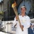 Former England striker Michael Owen poses with the Olympic Torch at Battersea dogs home in London