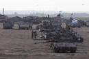 Israeli tanks and armoured personnel carriers are seen at a staging area outside the central Gaza Strip