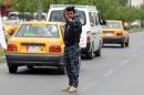 An Iraqi policeman organizes traffic on a main road in Baghdad on May 20, 2014