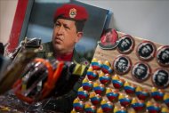 Fotografías y botones de Hugo Chávez, y otros símbolos relativos a su proyecto socialista, son exhibidos este 3 de enero, en una tienda de un mercado de Caracas (Venezuela). EFEFotografía cedida por Miraflores del vicepresidente de Venezuela, Nicolás Maduro (i), y el presidente de la Asamblea Nacional, Diosdado Cabello (d). Maduro aseguró que el mandatario Hugo Chávez, volverá al país "más temprano que tarde". EFE