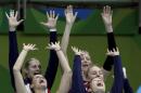 United States' Kelsey Robinson, left, and Courtney Thompson, right, raise there arms along with other members of their while watching the video board as a play is reviewed during a women's preliminary volleyball match against Italy at the 2016 Summer Olympics in Rio de Janeiro, Brazil, Friday, Aug. 12, 2016. (AP Photo/Jeff Roberson)