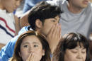 Japanese soccer fans react to a strong earthquake as they watch a J-League soccer match between the Shonan Bellmare and the Sanfrecce Hiroshima at BMW Stadium in Hiratsuka, southwest of Tokyo Saturday, May 30, 2015. A powerful and extremely deep earthquake struck a group of remote Japanese islands and shook Tokyo on Saturday, but officials said there was no danger of a tsunami, and no injuries or damage were immediately reported. (Munehide Someya/Kyodo News via AP)