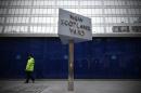 A police support officer walks past a sign outside New Scotland Yard, the headquarters of the Metropolitan Police, in central London on January 11, 2013