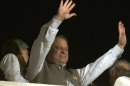 Former Prime Minister and leader of the Pakistan Muslim League-N party Nawaz Sharif waves to his supporters at a party office in Lahore, Pakistan, Saturday, May 11, 2013. Sharif declared victory following a historic election marred by violence Saturday, as unofficial, partial vote counts showed his party with an overwhelming lead. (AP Photo/K.M. Chaudary)