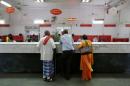 Customers wait to deposit their money inside a post office in New Delhi