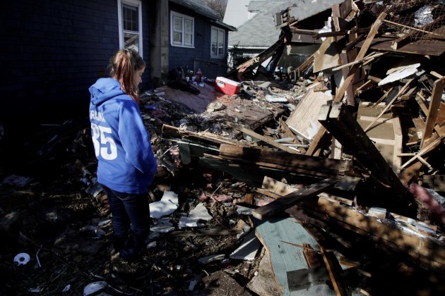 Kate Traina, 14, looks over the rumble of her grandparents house in Staten Island, N.Y., Friday, Nov. 2, 2012. Mayor Michael Bloomberg has come under fire for pressing ahead with the New York City Marathon. Some New Yorkers say holding the 26.2-mile race would be insensitive and divert police and other important resources when many are still suffering from Superstorm Sandy. The course runs from the Verrazano-Narrows Bridge on hard-hit Staten Island to Central Park, sending runners through all five boroughs. The course will not be changed, since there was little damage along the route. (AP Photo/Seth Wenig)