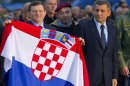 Croatian Gen. Ante Gotovina, right and Gen. Mladen Markac hold the Croatian flag upon their arrival to the airport in Zagreb, Croatia, Friday, Nov. 16, 2012. The Yugoslav war crimes tribunal overturned the convictions of the two Croat generals on Friday for murdering and illegally expelling Serb civilians in a 1995 military blitz, and ordered both men to be freed immediately. (AP Photo/Nikola Solic)
