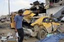 A man looks at damages at the site of a car bomb attack in Baghdad