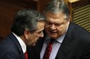 Greek Prime Minister Antonis Samaras, left, speaks with Socialist Leader Evangelos Venizelos at the Parliament during a debate on the new government's policy agenda before staging a vote of confidence in Athens, late Sunday July 8, 2012. (AP Photo/Kostas Tsironis)