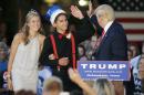 Republican presidential candidate, businessman Donald Trump high-fives homecoming king Austin Cook as queen Eylse Pescott, left, looks on during a rally at Urbandale High School, Saturday, Sept. 19, 2015, in Urbandale, Iowa. (AP Photo/Charlie Neibergall)