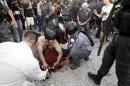 People help cameraman Andrade Santiago after he was injured during a protest in Rio de Janeiro