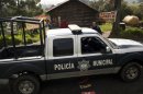A municipal police truck arrives to the entrance of Rancho la Mesa, which leads to Rancho La Negra in Tlalmanalco, Mexico, Thursday, Aug. 22, 2013. Mexican authorities said Thursday that they have found a mass grave east of Mexico City and are testing to determine if it holds some of the 12 people who vanished from a bar in an upscale area of the capital nearly three months ago. (AP Photo/Ivan Pierre Aguirre)
