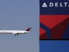 In this Saturday,  April 6, 2013, photo, a Delta Airlines jet flies past the company's billboard at Citi Field, in New York. Delta Air Lines Inc. reports quarterly financial results before the market opens Tuesday, April, 23, 2013. (AP Photo/Mark Lennihan)