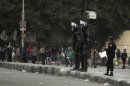 Riot police try to stop clashes and ask protesters, opposing Egyptian President Mohamed Mursi, to back away in Cairo