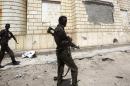 Somali government soldiers patrol near the scene of a suicide car explosion outside the Somali parliament building in Mogadishu