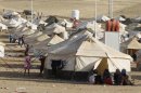 Syrian refugees rest at a new refugee camp on the outskirts of the city of Arbil