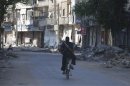 A fighter from Free Army rides his bicycle in Daraya town near Damascus