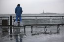 A man watches the rising tides in Battery Park as Hurricane Sandy makes its approach in New York