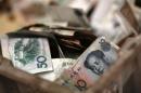 Chinese banknotes are seen at a vendor's cash box at a market in Beijing