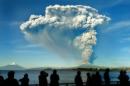People watch from Puerto Varas, southern Chile, as a high column of ash and lava spews from the Calbuco volcano, on April 22, 2015