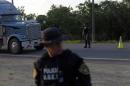 Border police officers stand on Highway CA13 at a checkpoint near the Honduran border with Guatemala