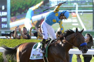 Victor Espinoza reacts after crossing the finish line with American Pharoah to win the Triple Crown. (AP)