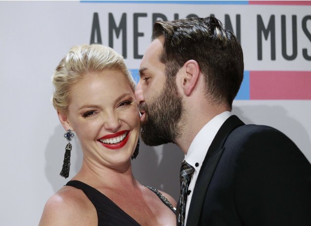 Singer Josh Kelley kisses his wife actress Katherine Heigl backstage at the 2011 American Music Awards in Los Angeles