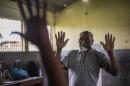 A Mozambican man shows his hands to electoral officials before marking his ballot at a polling station in Maputo on October 15, 2014