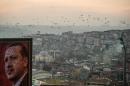 A poster of Turkish President Recep Tayyip Erdogan is seen over Kasimpasa district during a sunset on December 26, 2015 in Istanbul