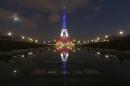 The Eiffel Tower lit with the blue, white and red colours of the French flag is reflected in the Trocadero fountains in Paris