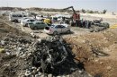 Security personnel and Civil defence personnel work at the site of a bomb attack in Kirkuk