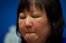 Carol Todd fights back tears as she listens during a Royal Canadian Mounted Police news conference in Surrey, British Columbia, on Thursday, April 17, 2014. A 35-year-old man alleged to be involved with the online extortion of Todd's 15-year-old daughter, who committed suicide in 2012, has been arrested in the Netherlands. (AP Photo/The Canadian Press, Darryl Dyck)
