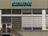 A man stands in front of a building of Siemens Schweiz AG Building Technologies Group a Swiss unit of German Siemens AG in Zug