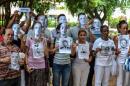 Cuban dissidents pose wearing masks depicting US President Barack Obama and holding pictures of imprisoned dissidents as they protest against the reopening of the US embassy in the island, on August 9, 2015