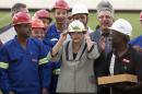 Brazil's President Dilma Rousseff, center, tries on a hard hat she was given as a gift from the construction workers, during her visit to the Itaquerao stadium in Sao Paulo, Brazil, Thursday, May 8, 2014. The still unfinished stadium will host the World Cup opener match between Brazil and Croatia on June 12. (AP Photo/Andre Penner)