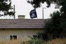File photo of an Islamic State flag flying over the custom office of Syria's Jarablus border gate as it is pictured from the Turkish town of Karkamis, in Gaziantep province