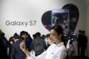 A model poses for photographs with Samsung Electronics' new smartphone Galaxy S7 during its launching ceremony in Seoul